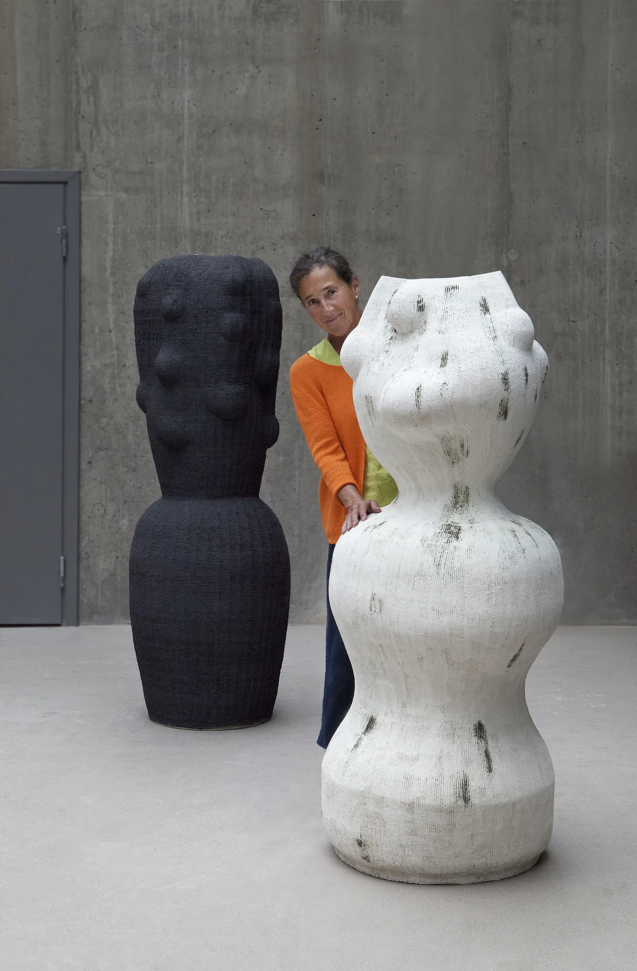 Kristina Riska in her studio between two large ceramic sculptures