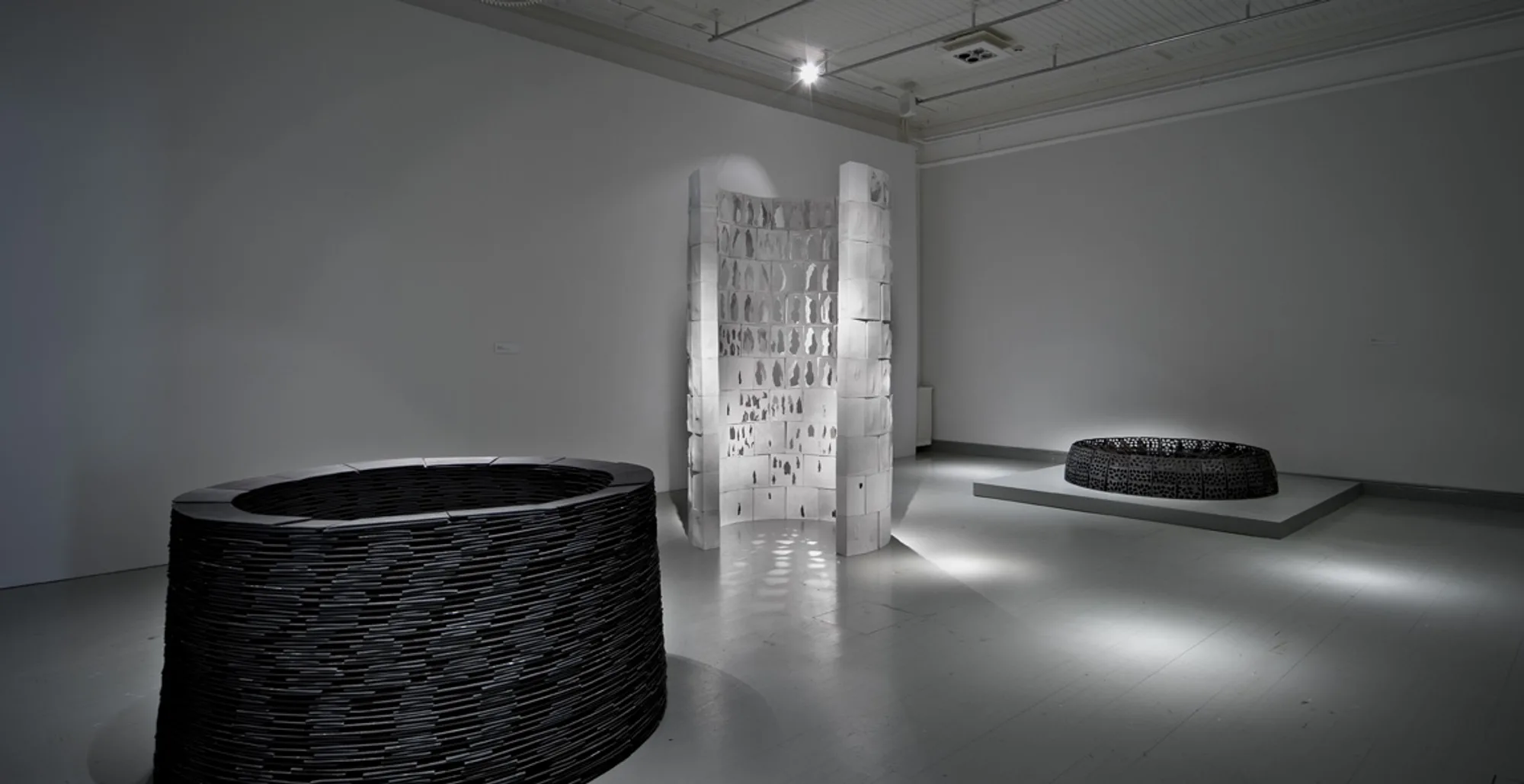 Group of rounded stoneware vessels on a gallery floor